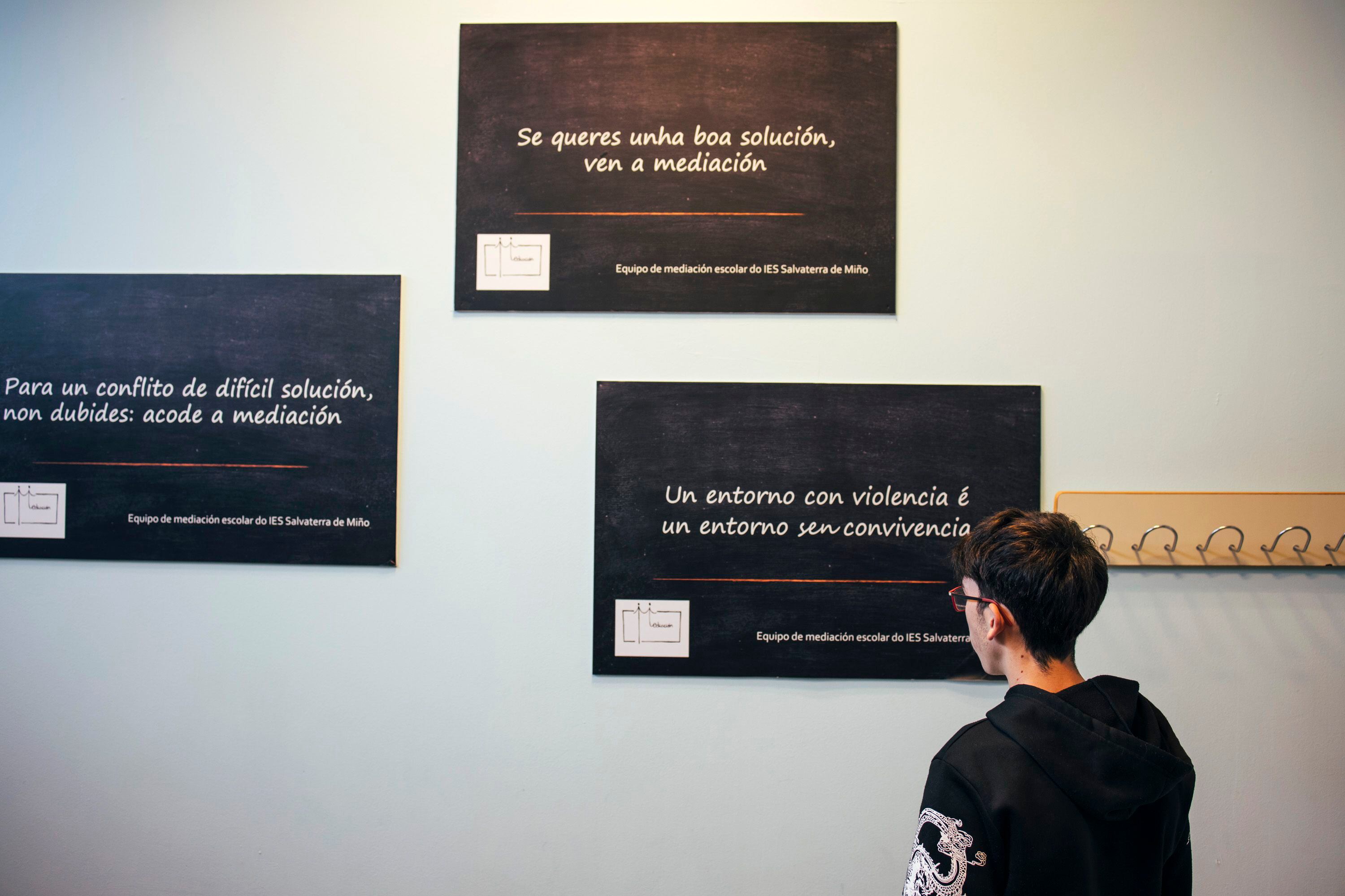 Un alumno del instituto de Salvaterra de Miño, en Pontevedra, mira unos carteles sobre la convivencia en el centro. 