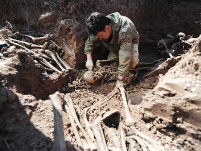 Un arqueólogo excava una fosa de común de soldados soviéticos fallecidos durante la Segunda Guerra Mundial, en el norte de Moscú, en 2009.