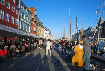 Músicos callejeros y casas de colores en el concurrido canal Nyhavn de Copenhague.