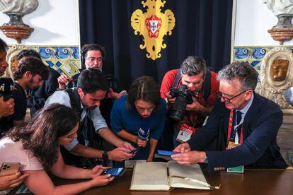 Varios periodistas se acercan al libro de honor, para leer las palabras escritas por el Papa, este miércoles en el Palacio de Belém en Lisboa. 