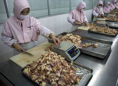 Trabajadores procesan carne de pollo en la planta que la multinacional estadounidense Tyson Foods tiene en la provincia de Shandong.