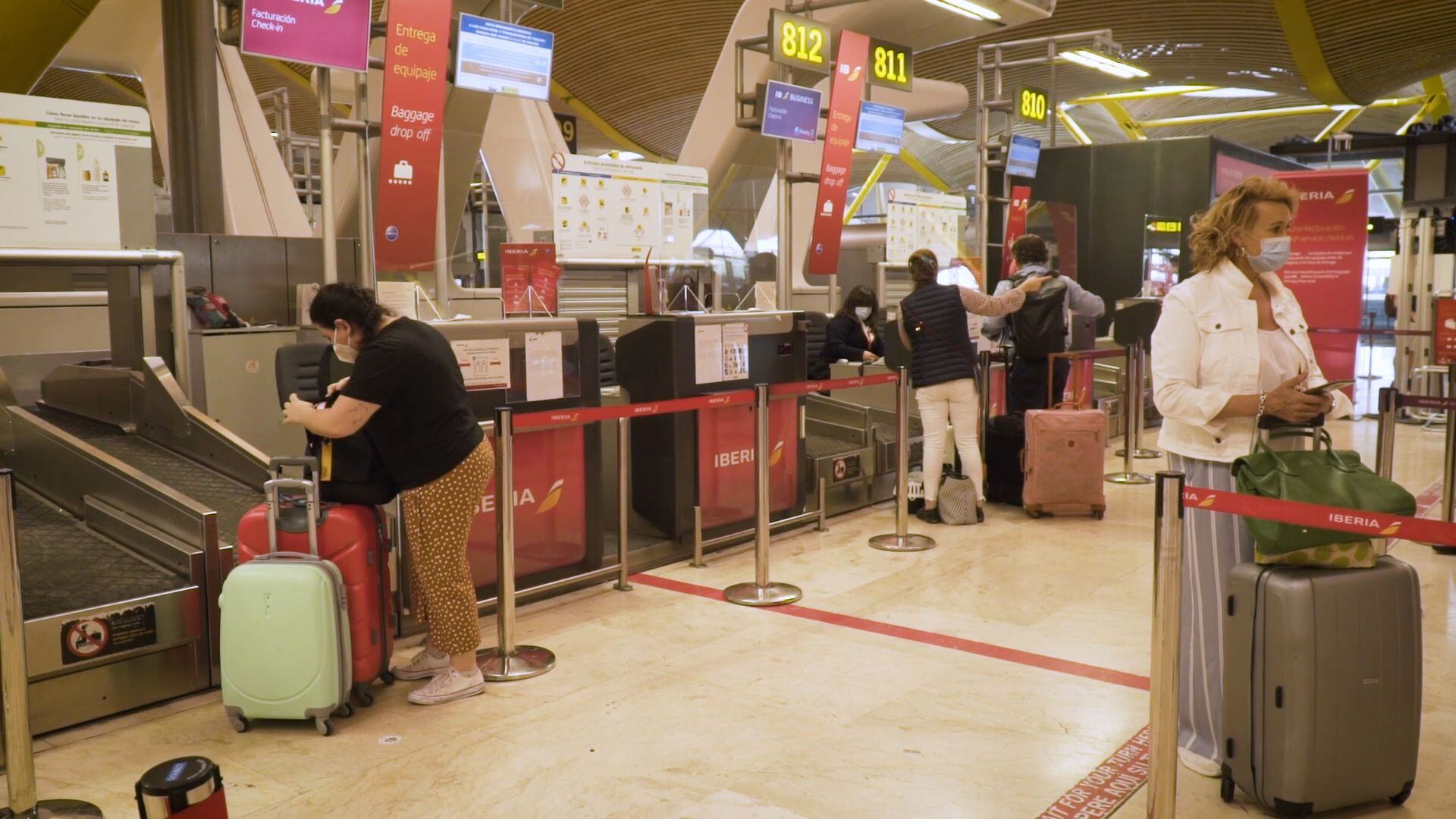 Varios pasajeros esperan para facturar su equipaje en Barajas (Madrid).
