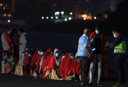 Un grupo de migrantes esperaban el 12 de mayo a ser interrogados por la policía fronteriza española en el puerto de Arguineguín, en Gran Canaria.