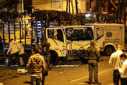 Security personnel inspect a National Police truck destroyed by an explosive device in Cali, Colombia, on January 8, 2022.