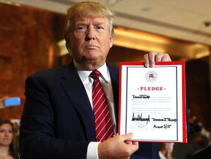 Trump con el documento de compromiso firmado.
