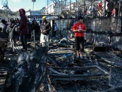 Varias personas junto a los restos del incendio dentro del campo de refugiados de Moria este lunes, en la isla griega de Lesbos.
