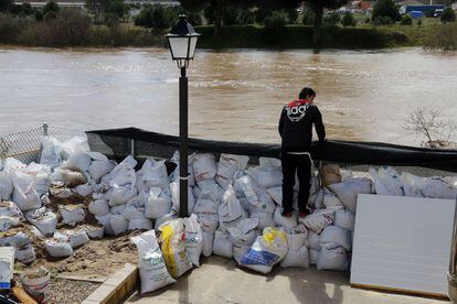 Un vecino de Puente Duero (Valladolid) protege su casa con sacos de tierra debido a la crecida del río Pisuerga.
