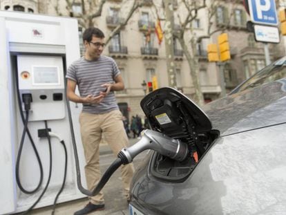 Un conductor recarga su coche eléctrico.