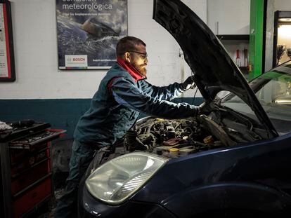Un mecánico trabaja en un taller de automoción en Valencia.