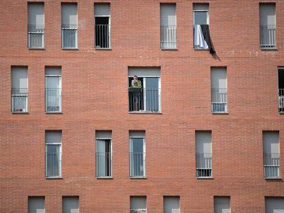 Un vecino fuma en una ventana de la calle Urrutia, en Nou Barris