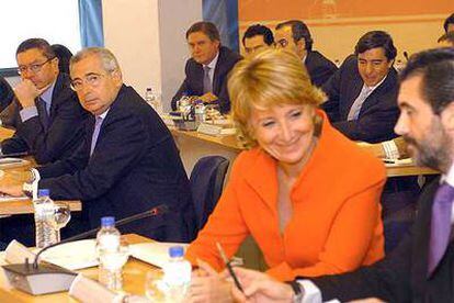 Esperanza Aguirre habla animadamente con Jaume Matas ante la seria mirada de Gallardón.