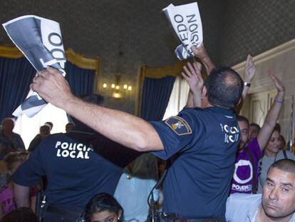 La Policía Local de Alicante requisa carteles de "Castedo Dimisión" en el pleno municipal.