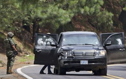 Militares mexicanos revisan el veh&iacute;culo de la Embajada estadounidense tiroteado en una autov&iacute;a de Cuernavaca.