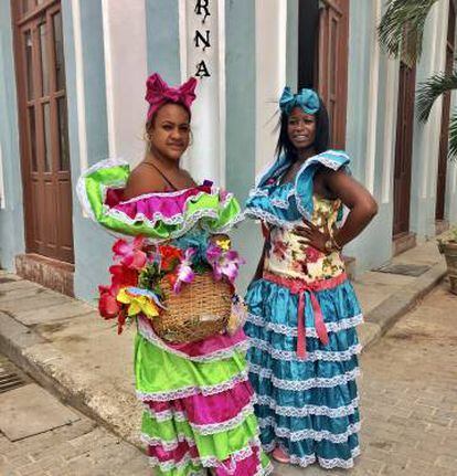 Dos mujeres posan para los turistas con el traje tradicional cubano en una esquina de la plaza Vieja.