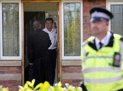 Gerry McCann (de blanco) atiende a un oficial de policía en su casa de Rothley, en el centro de Inglaterra.