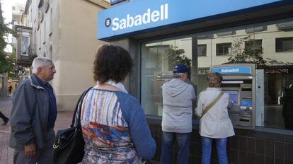 Colas en cajeros del Banco Sabadel en Terrassa.