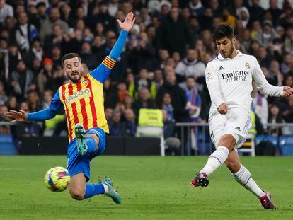 Marco Asensio remata ante José Gaya durante el partido entre el Real Madrid y el Valencia, en el Santiago Bernabéu este jueves.