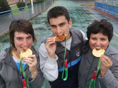 Romina, Nicol&aacute;s y Victoria muestran las medallas ganadas en Polonia.
