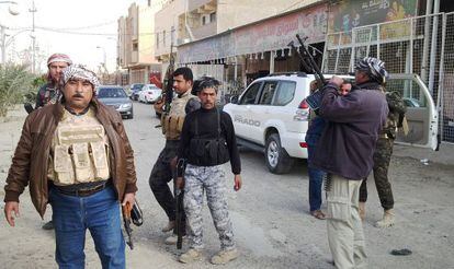 Soldados iraqu&iacute;es y varios civiles hacen guardia en Ramadi este jueves. 