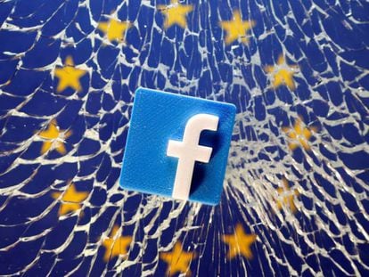 Un logo de Facebook en un cristal roto con la bandera europea en el fondo. En vídeo, declaraciones de Julian King, comisario europeo de Seguridad.