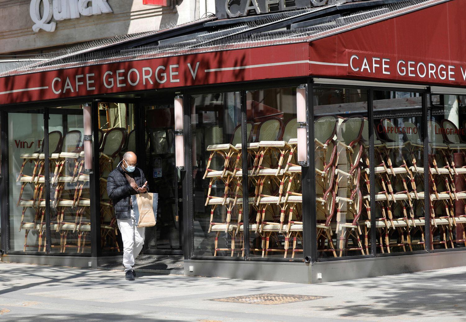 Un hombre, frente a un café cerrado en París.