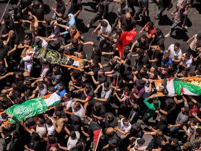 Decenas de personas llevan los cuerpos de los palestinos muertos en los enfrentamientos del día anterior en la operación militar israelí durante el funeral en Yenín, este 5 de julio.