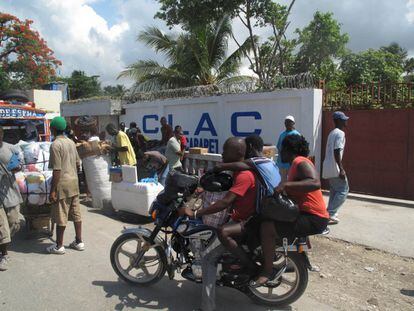Una moto-taxi pasa por un mercado en la carretera que va hacia Cabo Haitiano.