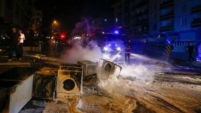 Un bombero extingue algunos de los productos quemados por manifestantes turcos durante su asalto a negocios y viviendas de refugiados sirios en el distrito de Altindag, en Ankara.