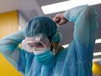 A healthcare worker wearing a protective suit gets ready to attend to a COVID-19 coronavirus patient at the Intensive Unit Care (ICU) of the Vall d'Hebron Hospital in Barcelona on April 6, 2020. - Spain declared a fourth consecutive drop in the number of coronavirus-related deaths with 637 over the past 24 hours, the lowest number in nearly two weeks. (Photo by PAU BARRENA / AFP)