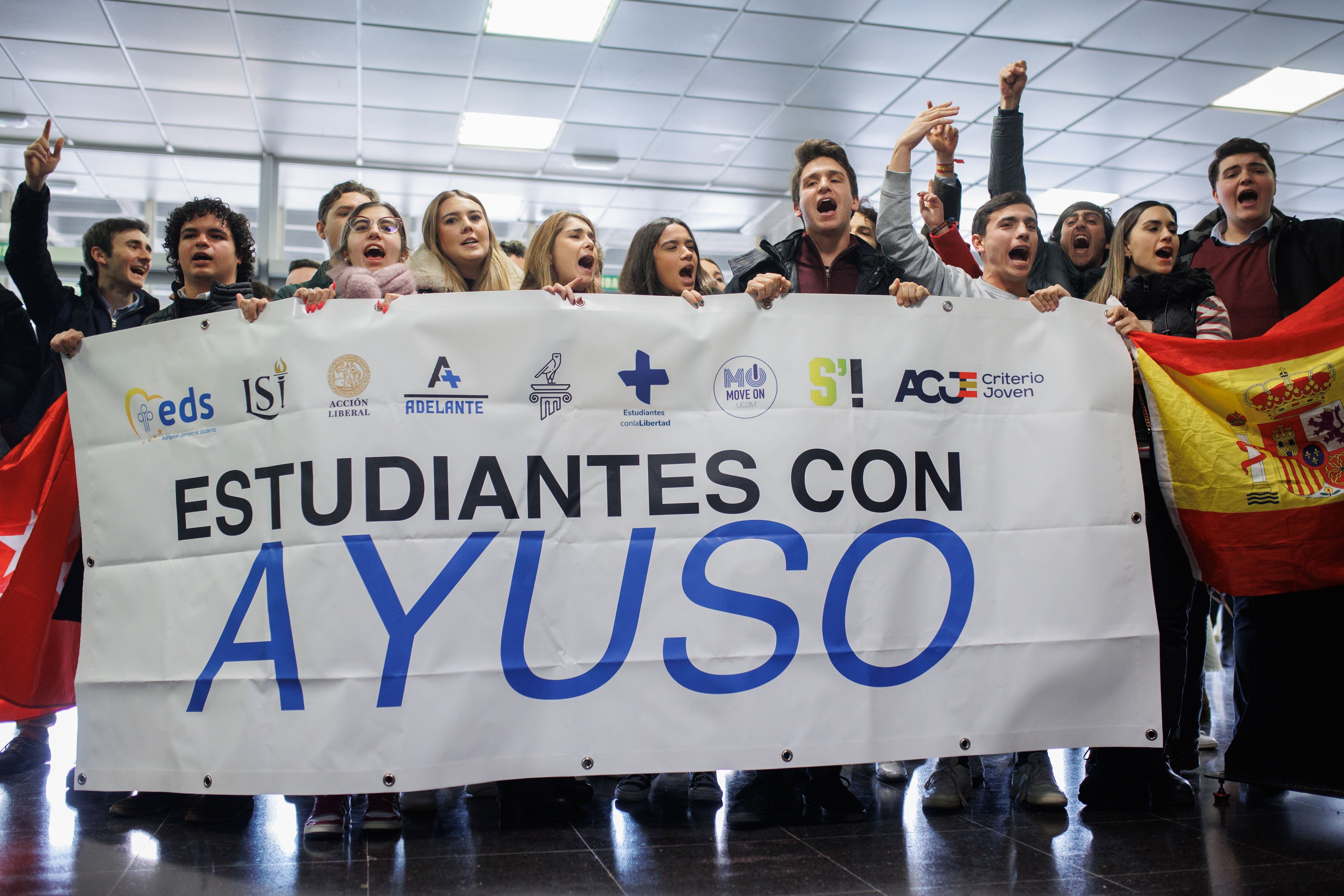 Varios estudiantes sujetan una pancarta en apoyo a la presidenta Isabel Díaz Ayuso.