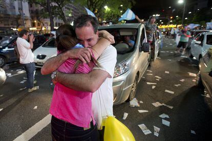 Varios partidarios del candidato presidencial Mauricio Macri se abrazan mientras celebran la victoria en Buenos Aires.