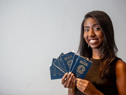 La viajera Nataly Castro posa con sus pasaportes en su casa, en São Paulo, después de la entrevista, el pasado martes.