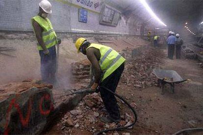 Dos obreros inmigrantes trabajan con un martillo neumático en las obras de la estación de metro de Callao.
