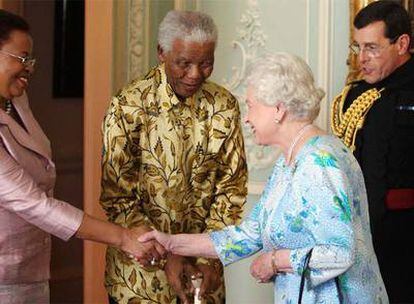 La esposa de Mandela, Graça Machel (izquierda), y el líder surafricano saludan a Isabel II el 23 de junio.