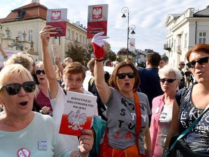 Manifestantes en Varsovia sostienen ejemplares de la Constitución polaca  este martes para protestar contra la reforma de la justicia impuesta por el Gobierno.
 