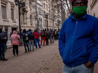 Personas con máscaras protectoras hacen fila afuera de una oficina de fondos de pensiones en Santiago, Chile, en 2020.
