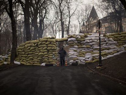 Un opositor al gobierno ucranio hace guardia en una barricada en Kiev.