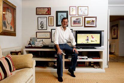Rajoy en el rincón favorito de su casa, con fotos y caricaturas que aprecia.