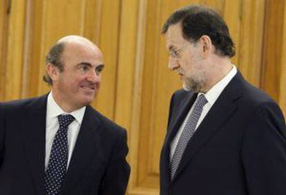 Rajoy conversa con Guindos, durante la ceremonia en la que el nuevo gobernador del Banco de Espa&ntilde;a ha prometido su cargo.