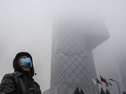 Un hombre camina junto al edicicio de CCTV, en Pekín (China). 
 