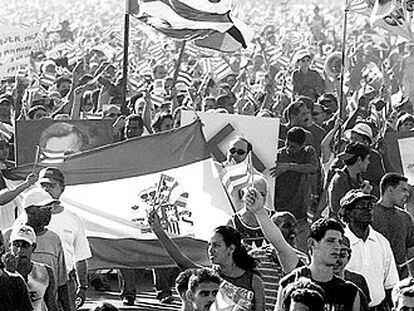 Manifestantes cubanos contra EE UU portan una bandera española en La Habana en mayo de 2004.