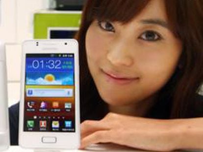 Una dependiente muestra un Samsung Galaxy S II junto con el Galaxy M