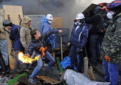 Un joven lanza un coctel molotov durante las duras protestas en el centro de Kiev, 19 de febrero de 2014.
