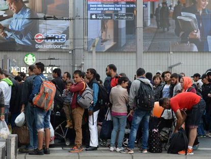 Decenas de migrantes aguardan para coger un tren en una estaci&oacute;n de M&uacute;nich (Alemania), en septiembre de 2015. 