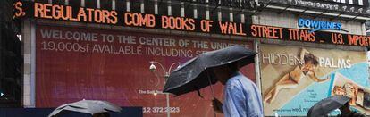 Los transeúntes de Times Square observan los titulares sobre la crisis de las subprime, en 2007.