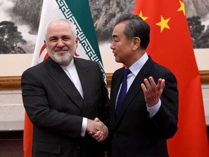 El ministro de Exteriores de China, Wang Yi (der.), habla con su homólogo iraní Mohammad Javad Zarif, el pasado 31 de diciembre.