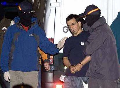 Agentes de la Guardia Civil se llevan esposado a uno de los ocho arrestados para registrar un inmueble en Andoain.