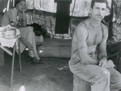 Un leñador parado acude con su mujer a la recogida de judías.. Lleva en su brazo tatuado el número de seguridad social. Oregón, 1939
