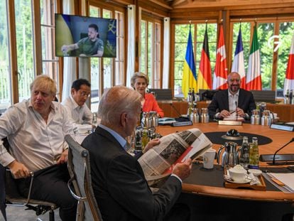 En primer plano, Joe Biden lee un periódico al inicio de la reunión este lunes con el resto de dirigentes del G-7, en el castillo de Elmau, Alemania.