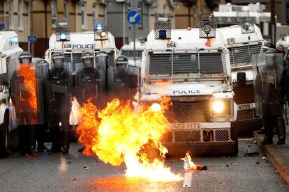 Despliegue de la policía antidisturbios frente a un fuego, durante las protestas el jueves en Belfast.